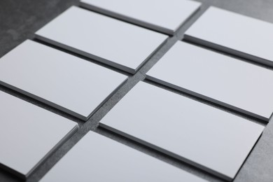 Photo of Blank business cards on grey textured table, closeup. Mockup for design
