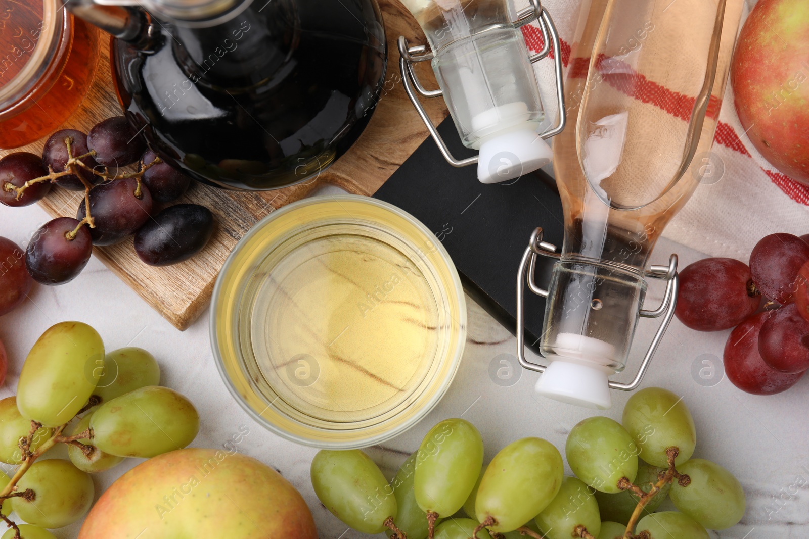 Photo of Different types of vinegar and fresh fruits on white table, flat lay