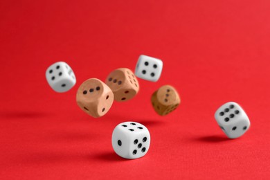Photo of Many color game dices falling on red background