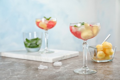 Photo of Glass with tasty watermelon and melon ball drink on table