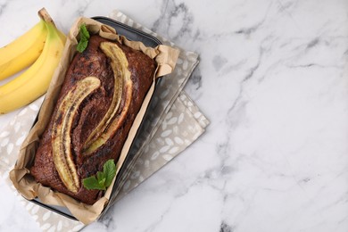 Photo of Delicious banana bread and fresh fruits on white marble table, top view. Space for text