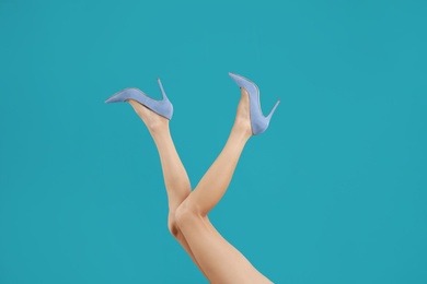 Photo of Woman in elegant shoes on light blue background