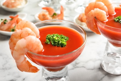 Photo of Glasses with boiled shrimps and tomato sauce on light background