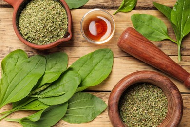 Photo of Flat lay composition with fresh and dried broadleaf plantain on wooden table