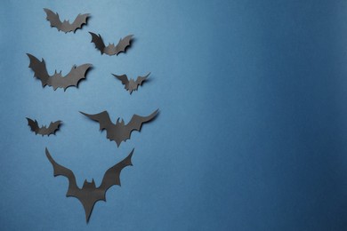 Photo of Many paper bats on dark blue background, flat lay with space for text. Halloween celebration