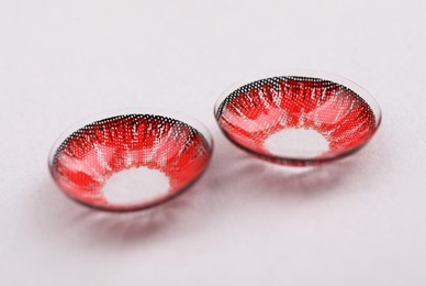 Photo of Two red contact lenses on white background