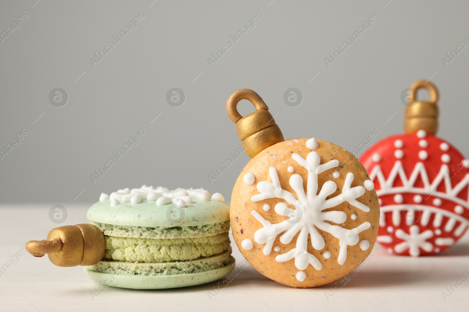 Photo of Beautifully decorated Christmas macarons on white wooden table