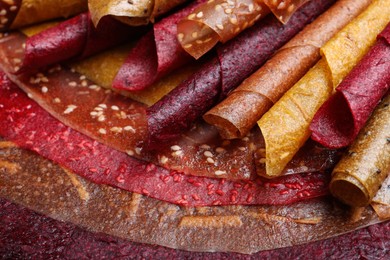 Photo of Delicious fruit leather rolls as background, closeup