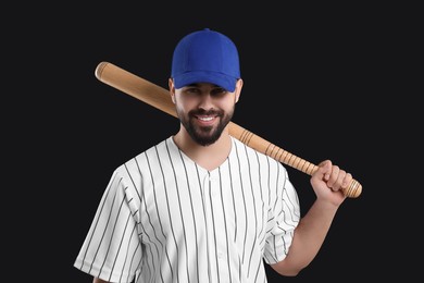 Photo of Man in stylish blue baseball cap holding bat on black background