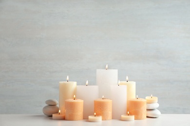Photo of Beautiful composition with candles on table against light background. Space for text