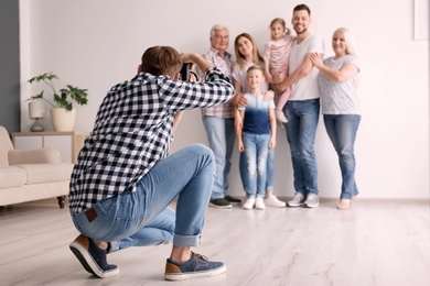 Photo of Professional photographer taking photo of family in studio