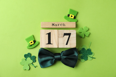 Photo of Flat lay composition with block calendar on light green background. St. Patrick's Day celebration