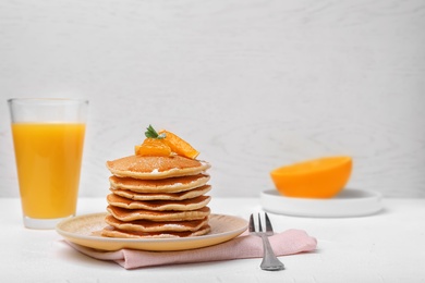 Photo of Tasty pancakes with orange on table