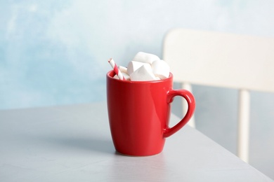 Photo of Delicious hot cocoa drink with marshmallows on table