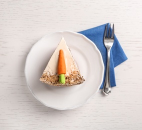 Photo of Plate with sweet carrot cake on white wooden table, top view