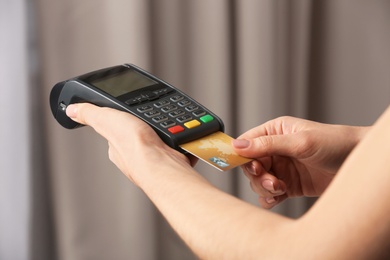 Photo of Woman using modern payment terminal indoors, closeup
