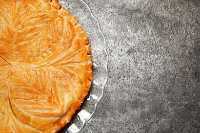 Photo of Traditional galette des rois on grey table, top view. Space for text