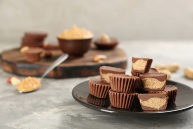 Photo of Delicious peanut butter cups on light grey table, space for text