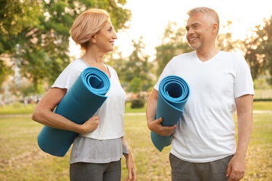 Photo of Couple with yoga mat in park at morning