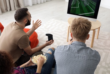 Photo of Emotional friends playing video games at home