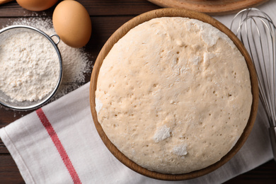 Photo of Bowl with dough for pastries on table, flat lay