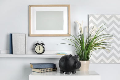Photo of Cute piggy bank on table indoors. Stylish interior