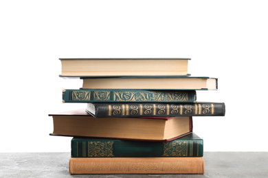 Photo of Stack of old vintage books on grey stone table against white background