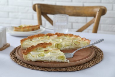 Photo of Board with tasty leek pie and cake server on table