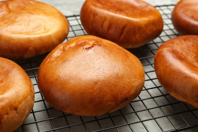 Many delicious baked patties on baking rack, closeup