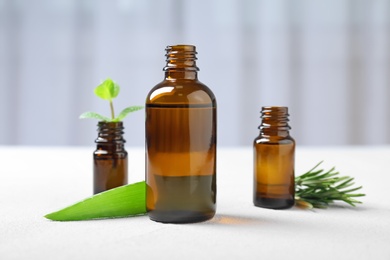 Photo of Bottles with essential oils and fresh herbs on table