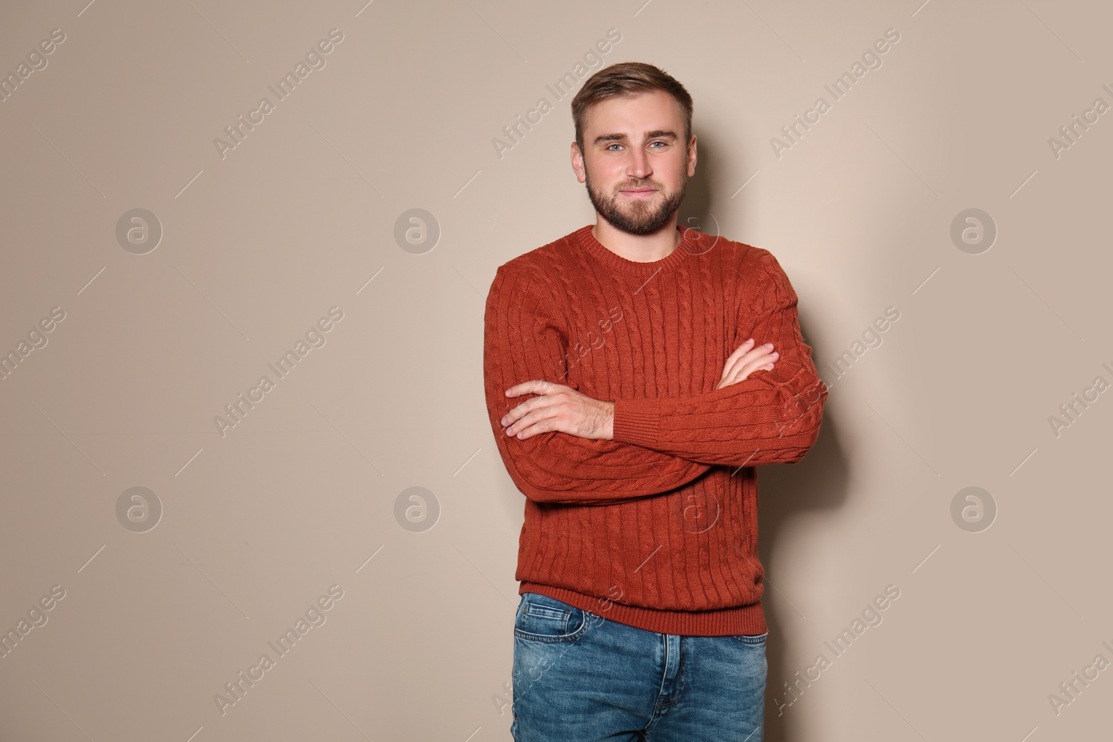 Image of Handsome man wearing warm sweater on beige background 