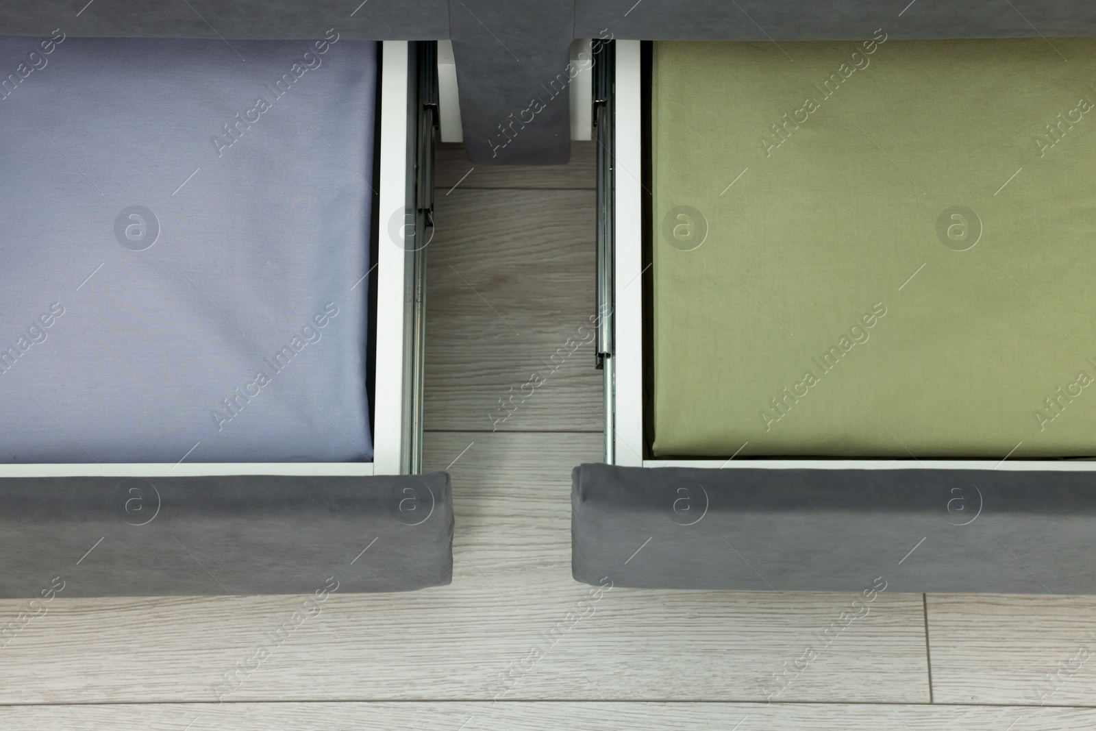 Photo of Storage drawers with bedding under comfortable bed in room, above view