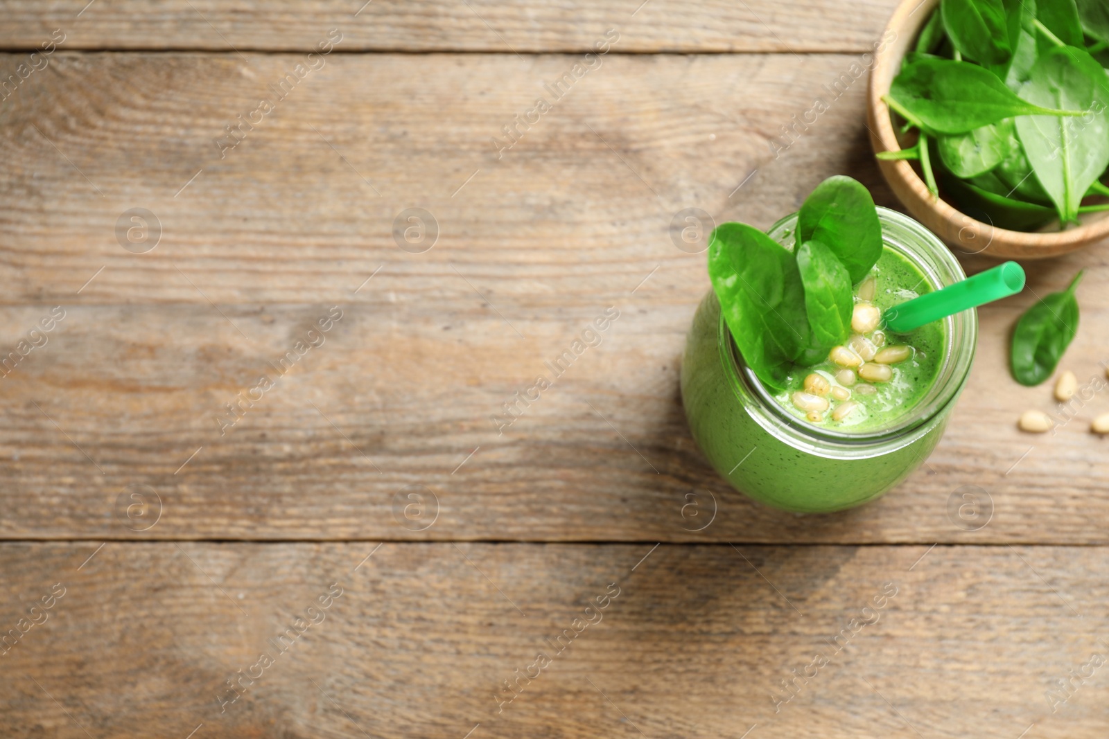 Photo of Flat lay composition with fresh green healthy spinach smoothie on wooden table, space for text