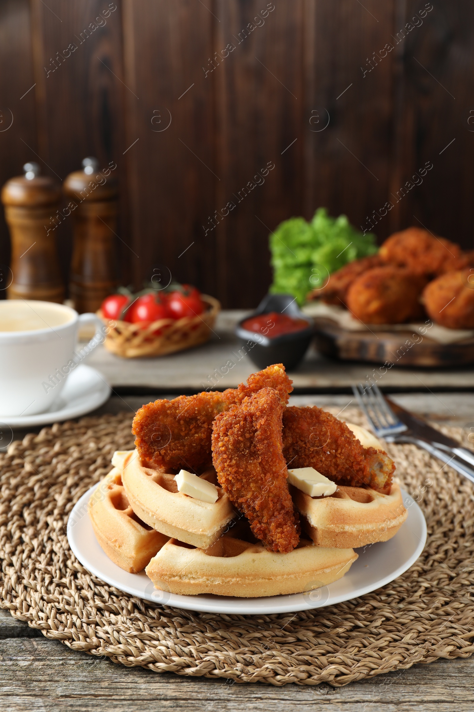 Photo of Delicious Belgium waffles served with fried chicken and butter on wooden table, space for text