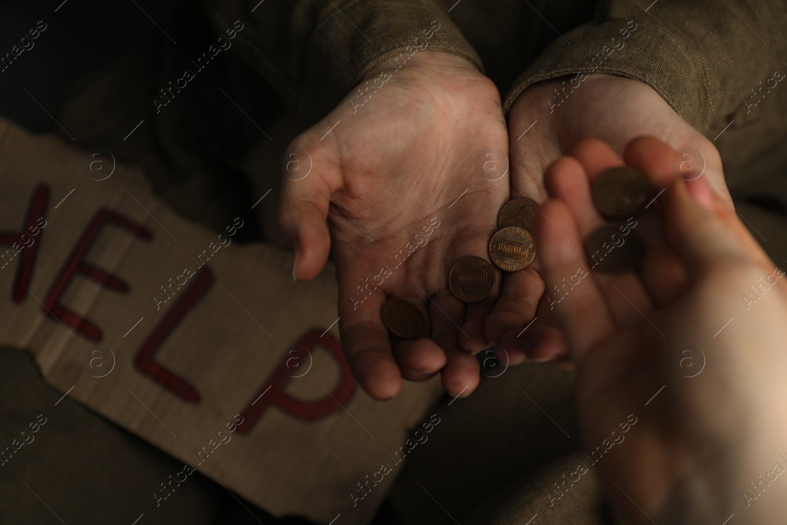 Photo of Woman giving coins to homeless, closeup. Charity and donation