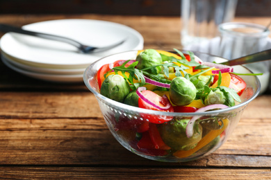 Photo of Tasty salad with Brussels sprouts served on wooden table