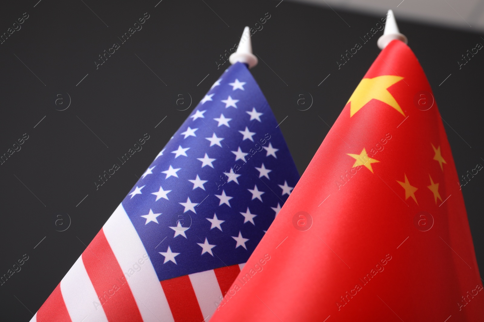 Photo of Closeup view of USA and China flags on dark background. International relations