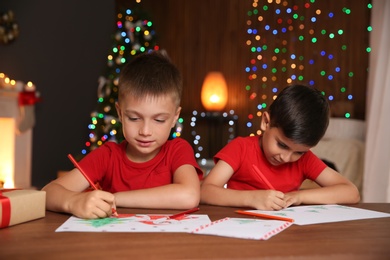 Photo of Little children drawing pictures at home. Christmas celebration