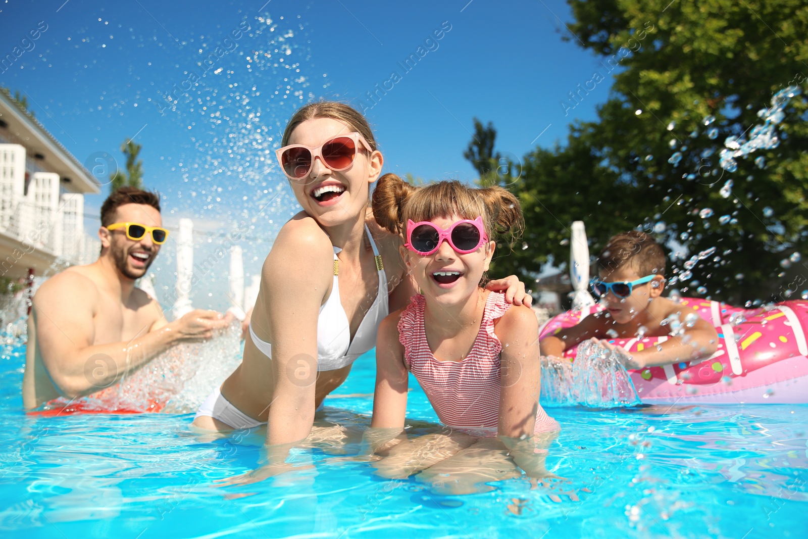 Photo of Happy family having fun in swimming pool