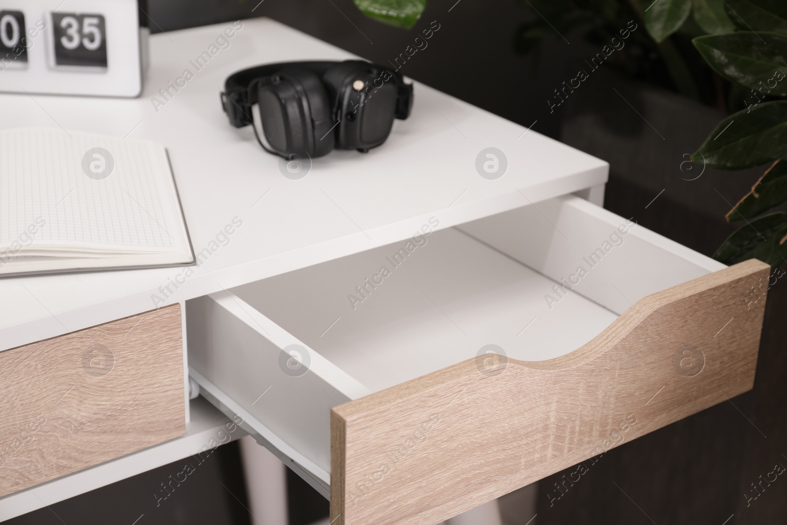 Photo of Stylish desk with open empty drawer in office