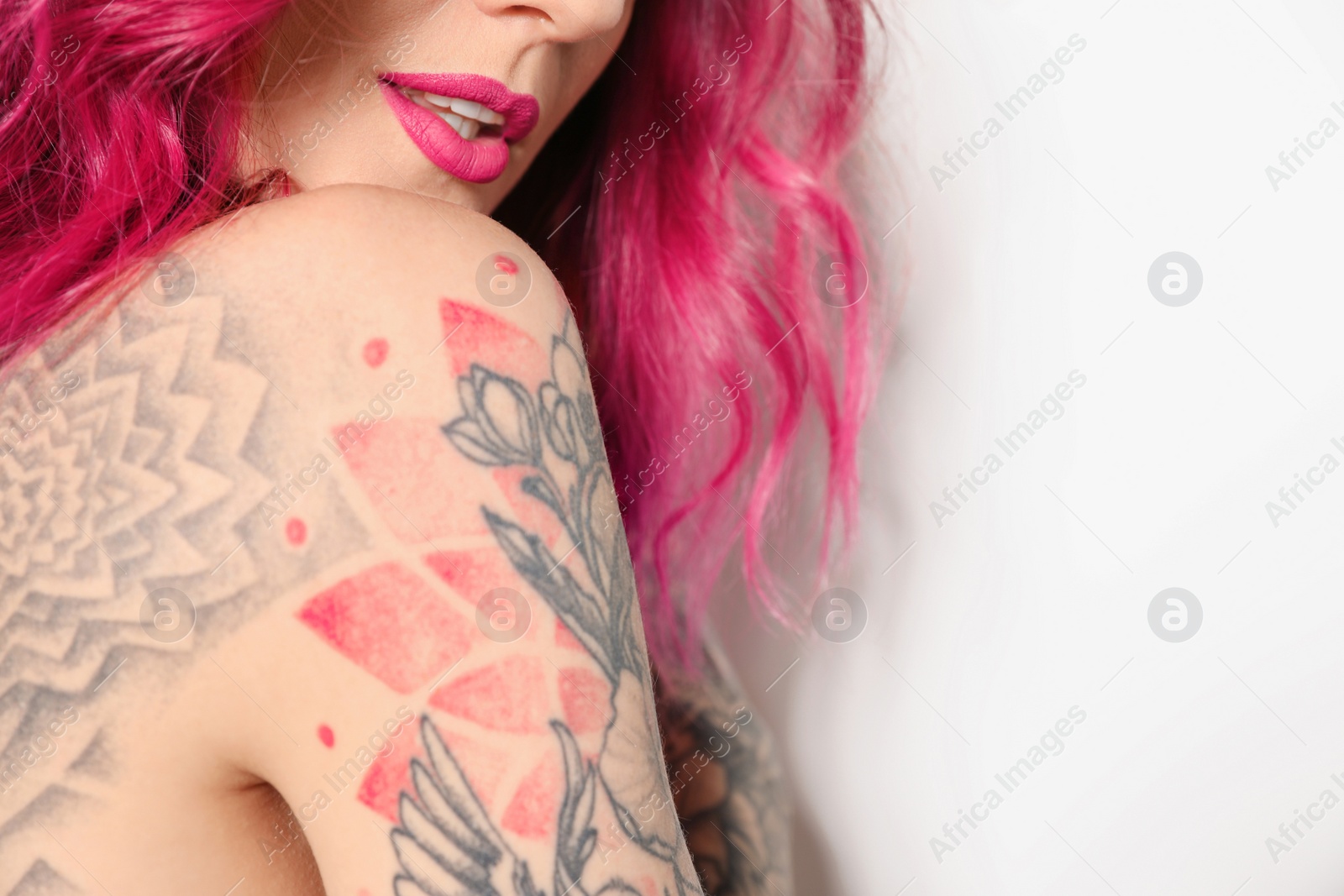 Photo of Beautiful woman with tattoos on body against white background, closeup