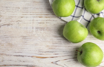 Flat lay composition of fresh ripe green apples on white wooden table, space for text