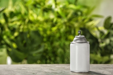 Photo of Spray air freshener on table against blurred background