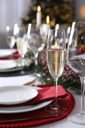 Photo of Christmas table setting with festive decor and dishware indoors, closeup