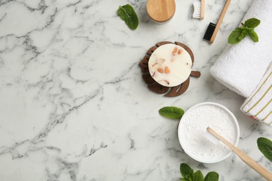 Flat lay composition with tooth powder and brushes on white marble table. Space for text