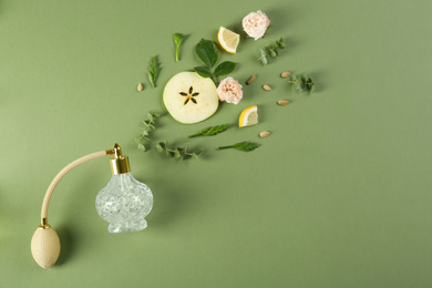 Photo of Flat lay composition with bottle of perfume on green background, space for text