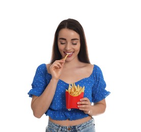 Beautiful young woman eating French fries on white background