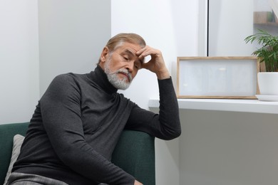 Photo of Upset senior man on sofa at home. Loneliness concept