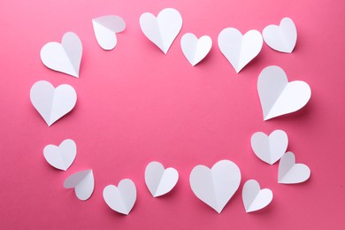 Frame of beautiful white paper hearts on pink background, flat lay. Space for text