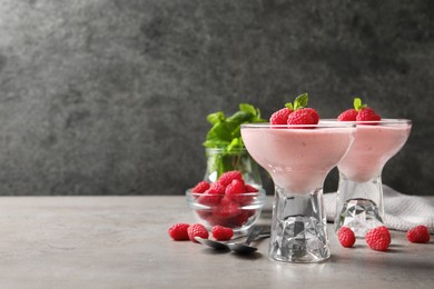 Photo of Delicious raspberry mousse with mint on light grey table, space for text